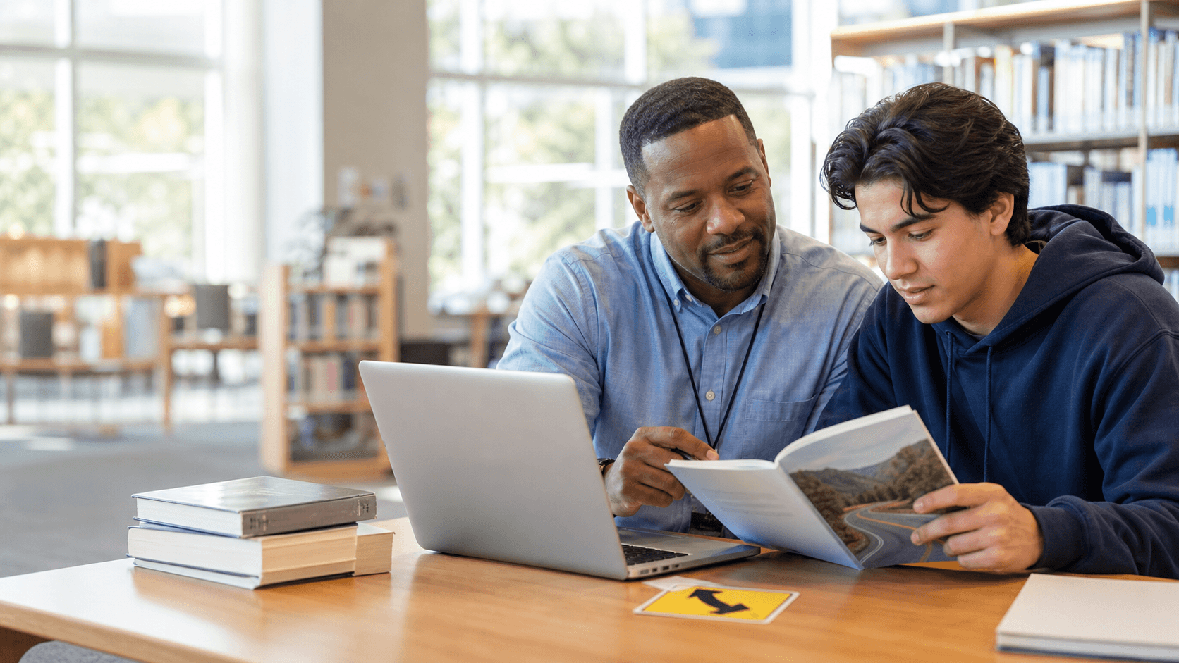 Library staff member helping a patron study from a driver handbook